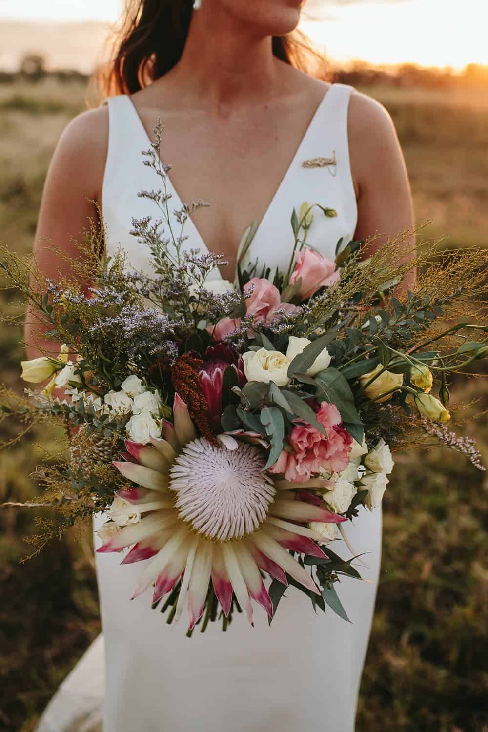 Close up image of a women in bridal gown holding floral bouquet